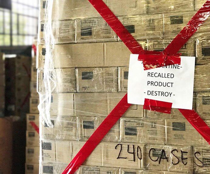 A shrink wrapped pallet containing stacks of recalled products in boxes needing to be destroyed.